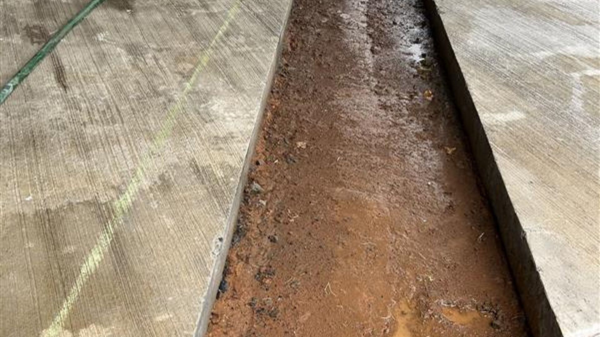 Rusty metal chute on a wooden surface