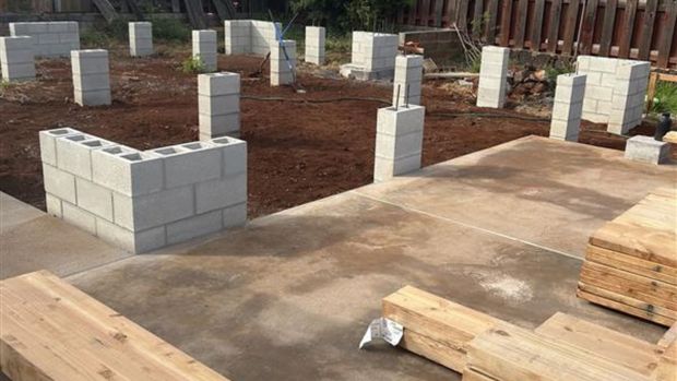 Construction site with partial cinder block walls and concrete slab foundation in progress
