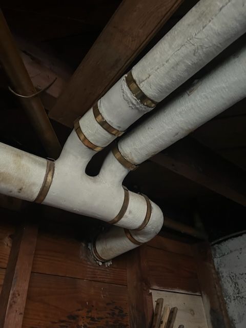 A bunch of pipes are hanging from the ceiling of a building.