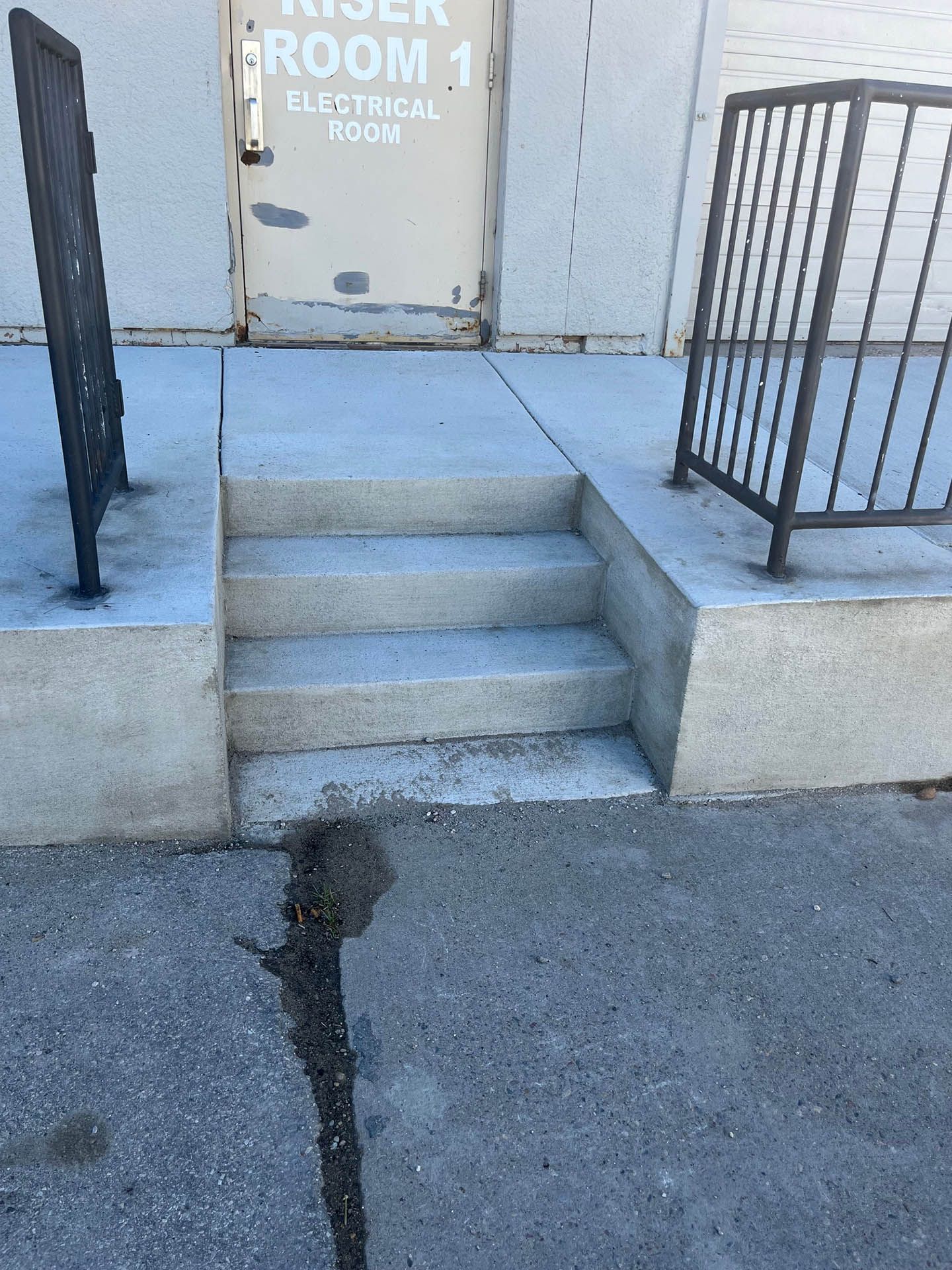 Two steps lead up to a beige door labeled 