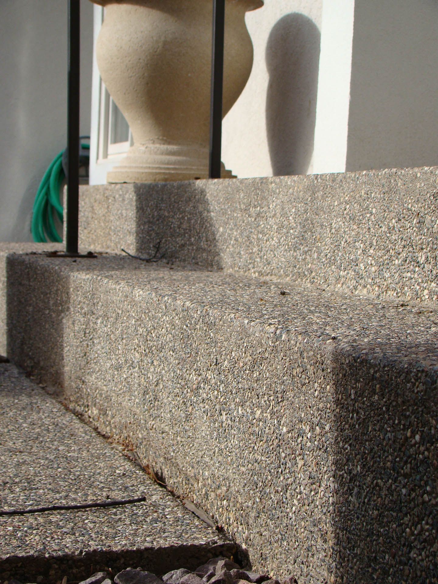 Close-up of stone steps leading to a building entrance with a decorative urn visible at the top.
