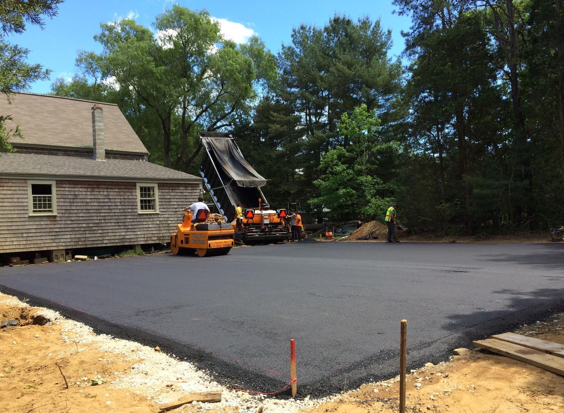 a large amount of asphalt is being rolled out in front of a house