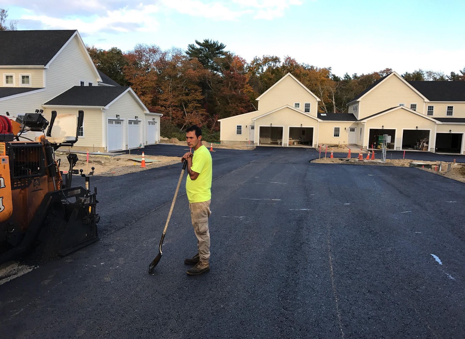 a man in a yellow shirt is working on a road