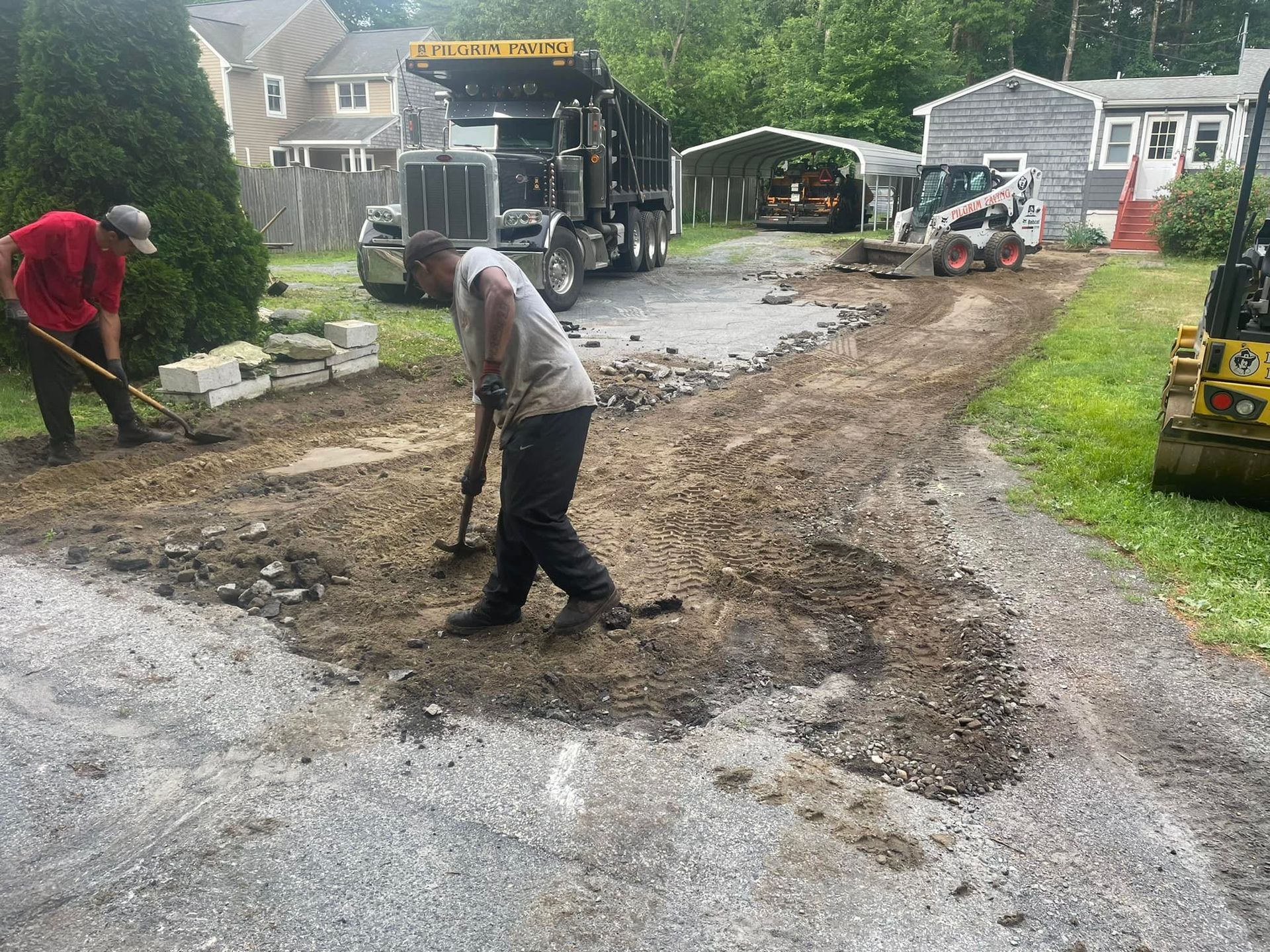 a man is standing next to a dump truck in a parking lot .