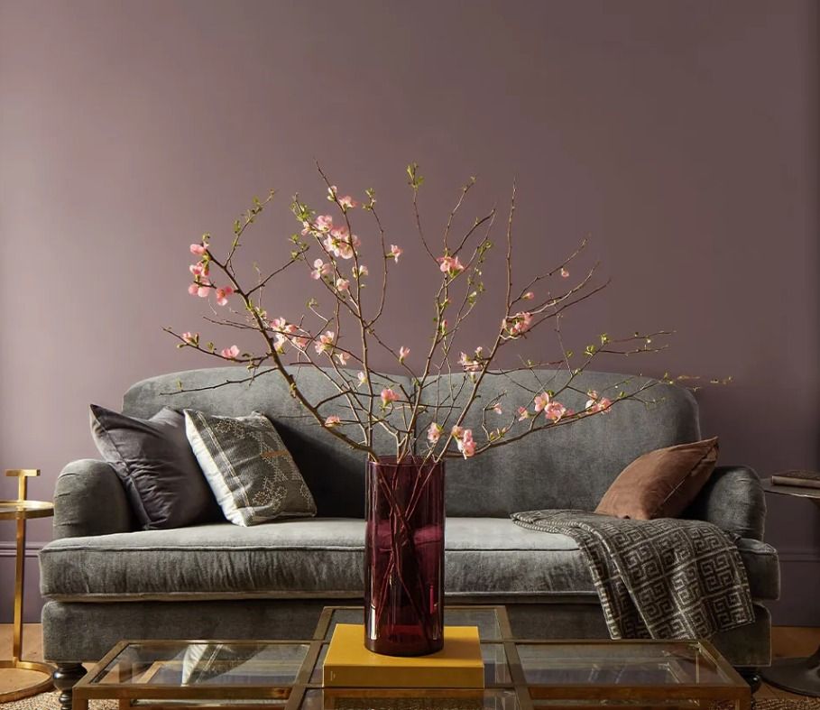 A living room with a couch and a vase of flowers