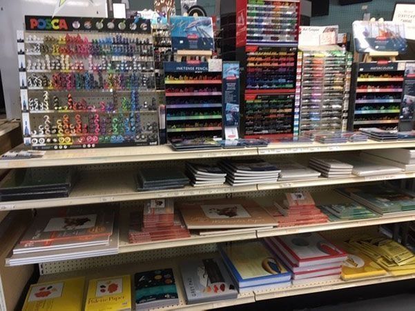 A store shelf filled with lots of books and markers.