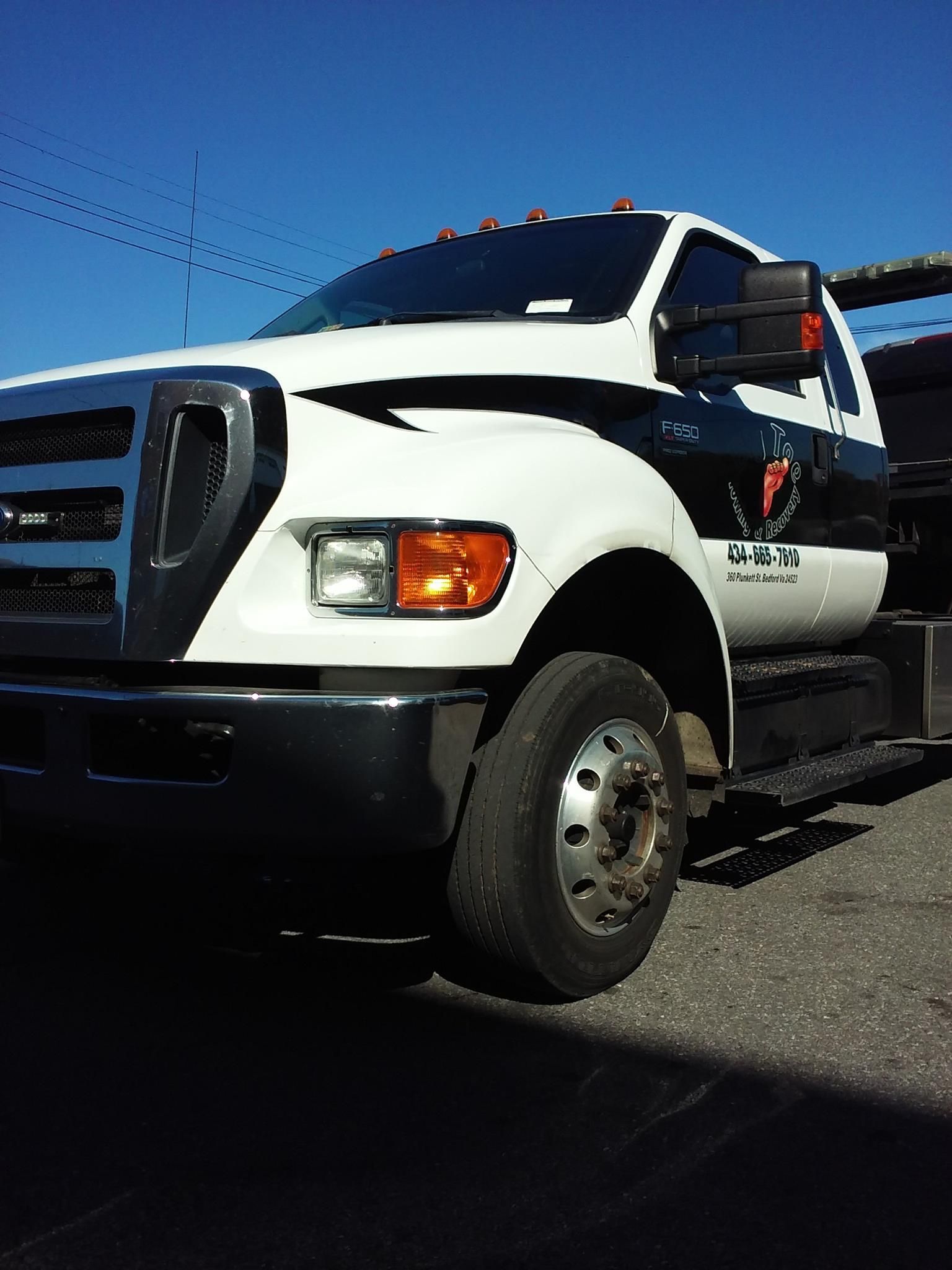 A white tow truck is parked on the side of the road