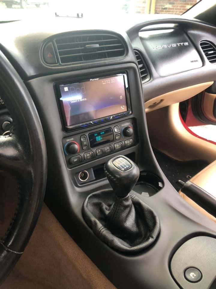 Black car interior with a center console, gear shift, and touchscreen radio.