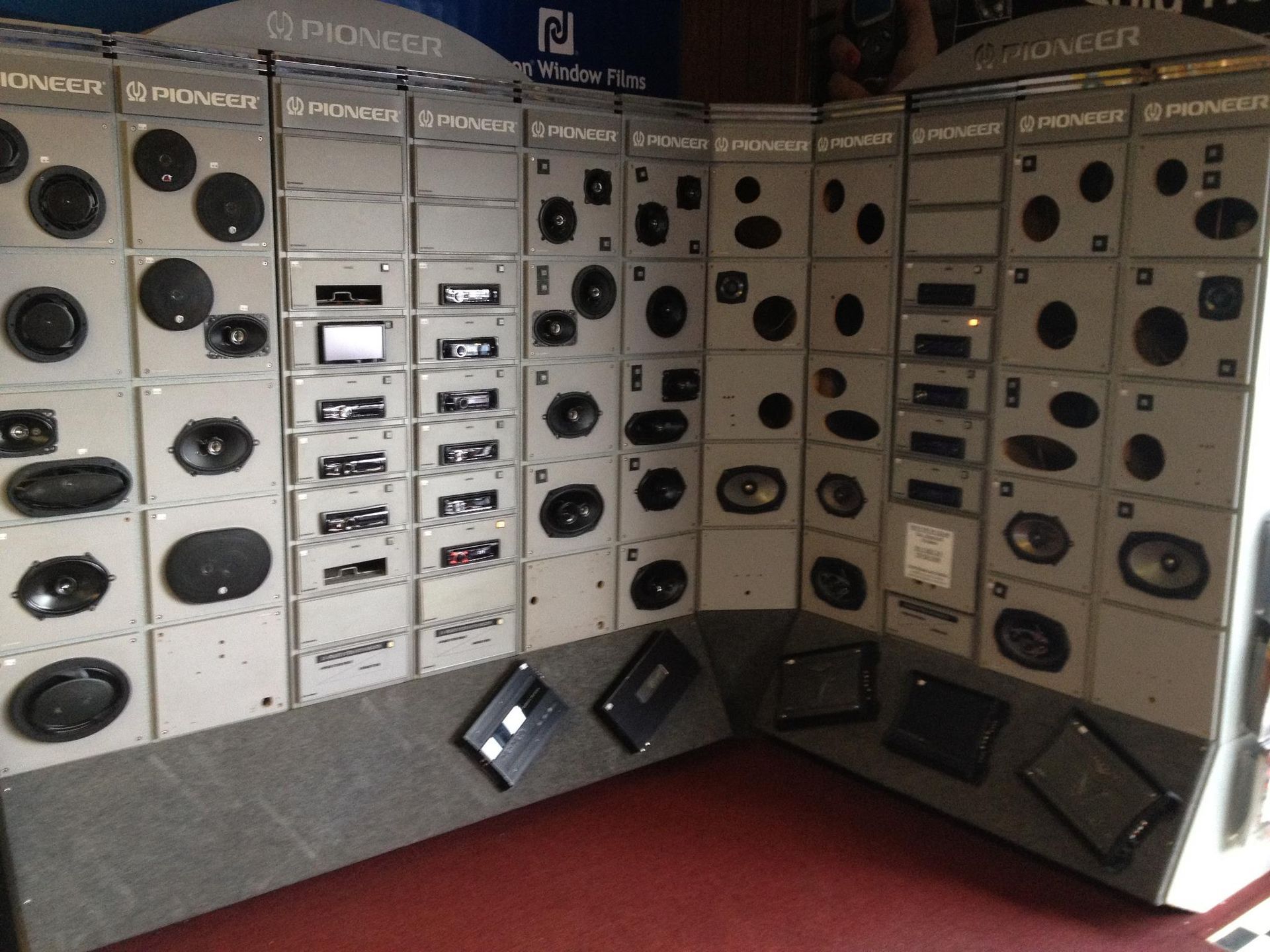 Display of car speakers and stereo head units on a store wall.
