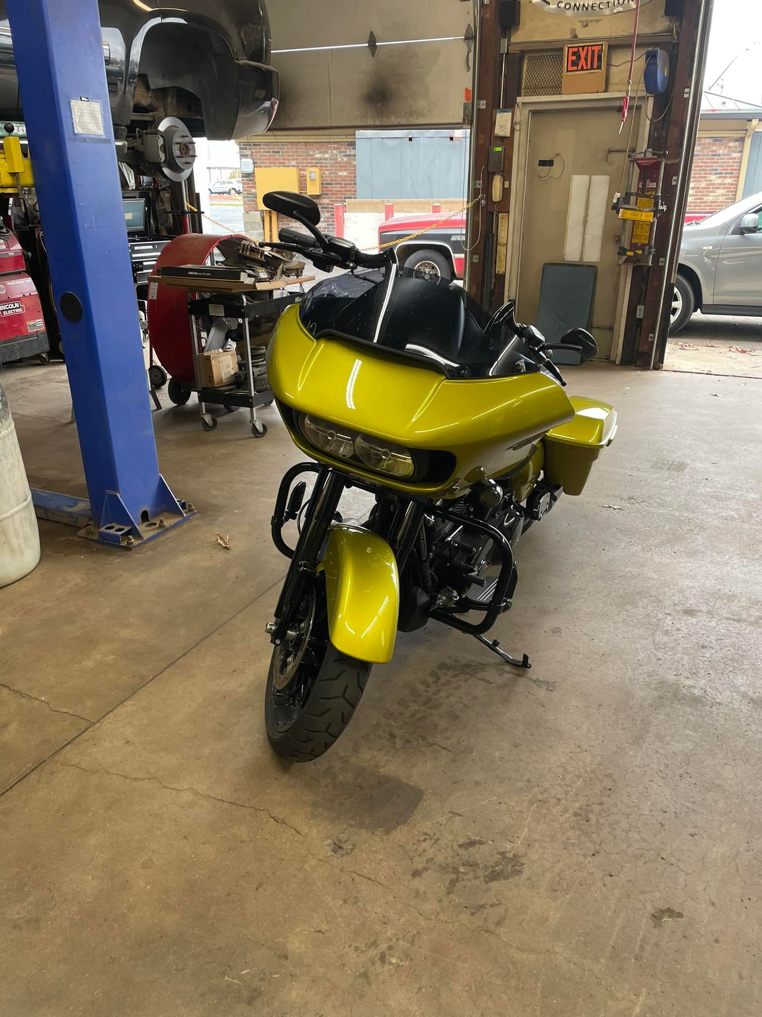 Yellow Harley Davidson motorcycle in a garage setting.