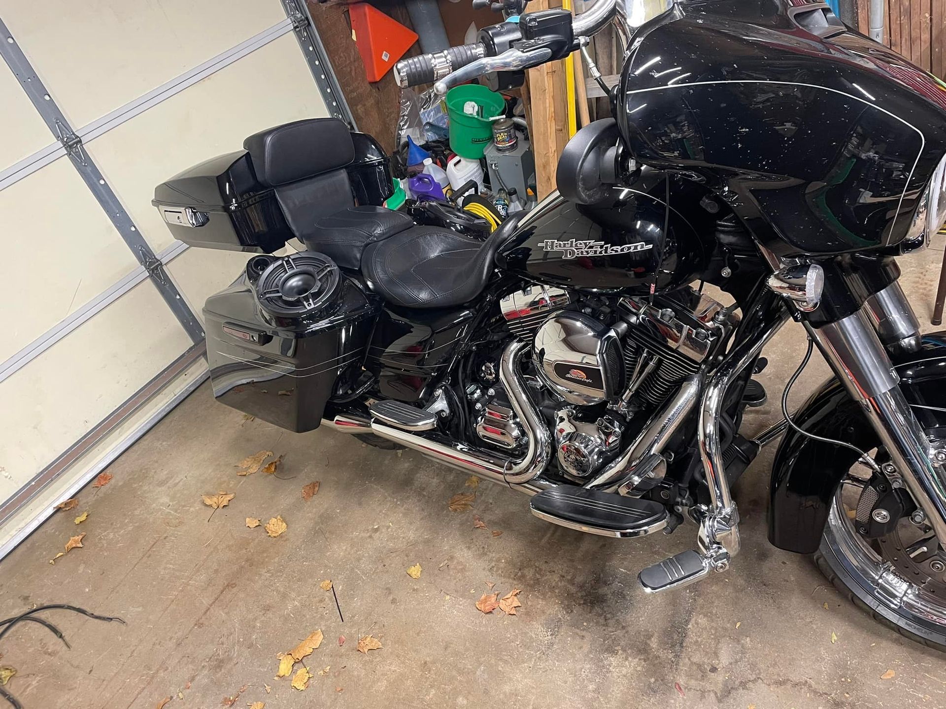 Black Harley Davidson motorcycle parked inside a garage with chrome accents.