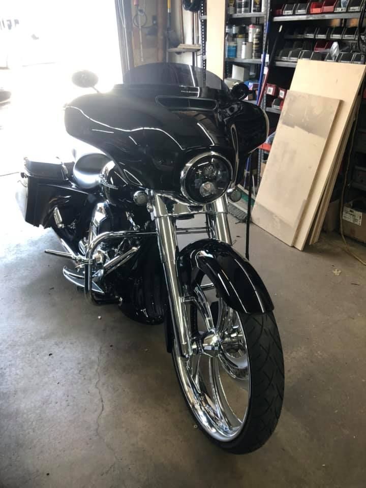 Black Harley Davidson motorcycle with chrome accents in a garage.