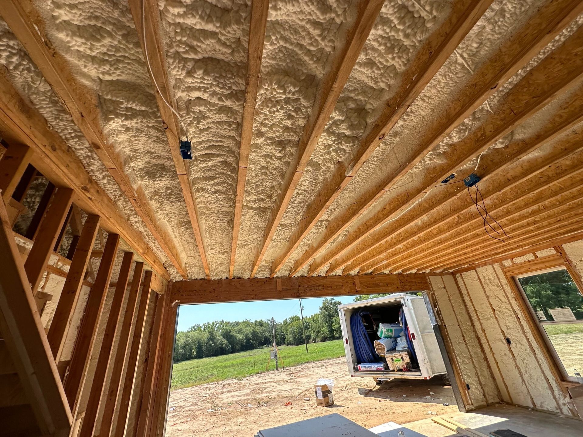 Wooden ceiling with spray foam insulation, construction site.