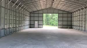 Interior of a large, empty metal building with open entrance.