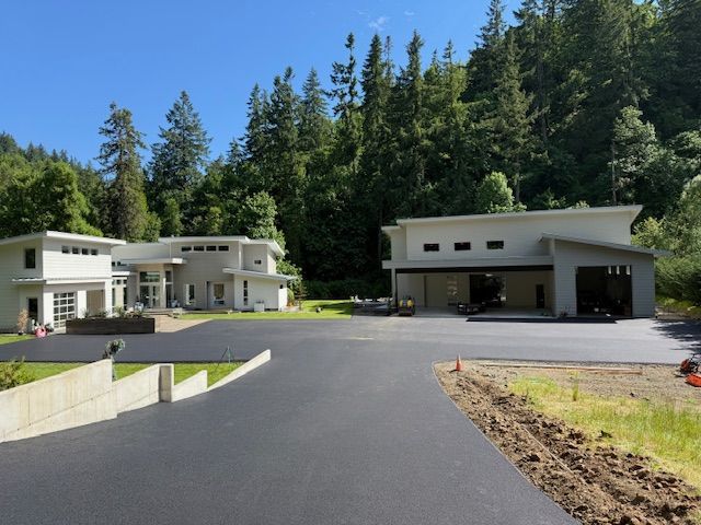 A large house with a garage is surrounded by trees
