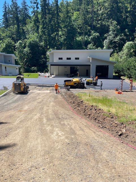 A dirt road leading to a house with trees in the background