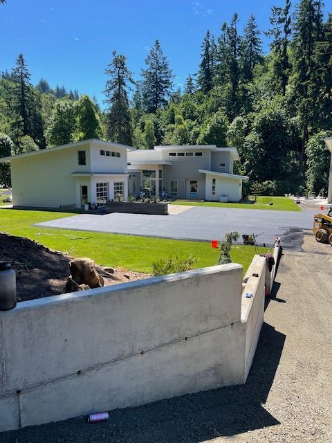 A large house sits in the middle of a lush green forest