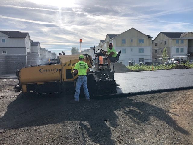 A group of construction workers are working on a road.