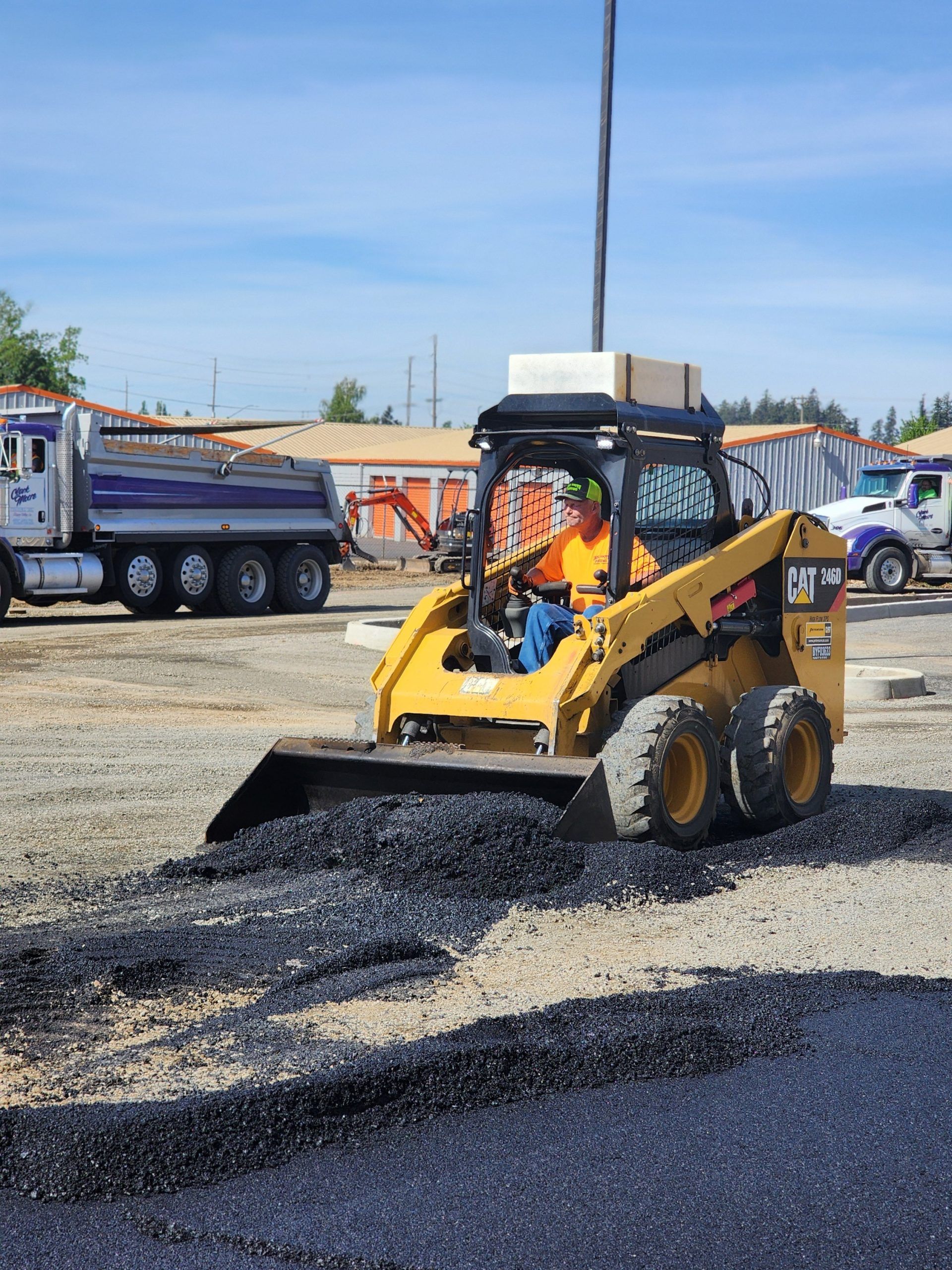 A man is driving a bulldozer in a parking lot.