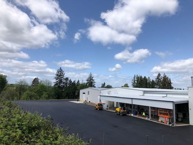 A large white building with a large parking lot in front of it.