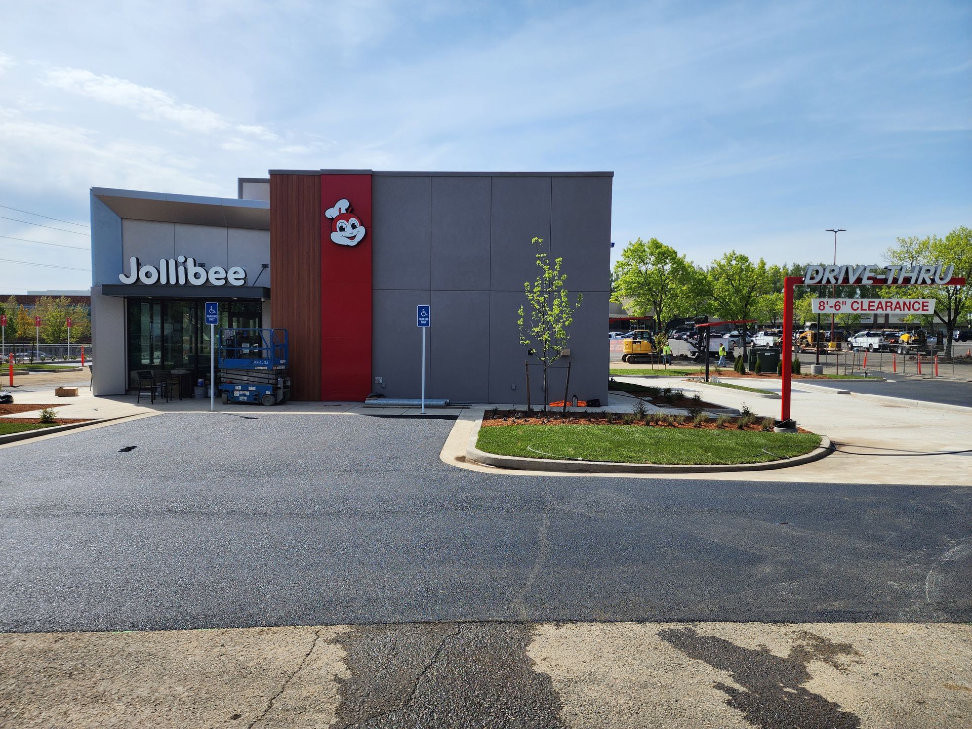 A jollibee restaurant is being built in a parking lot.