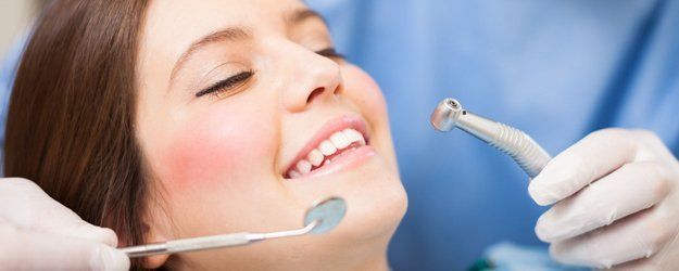 dentist examines patient's teeth
