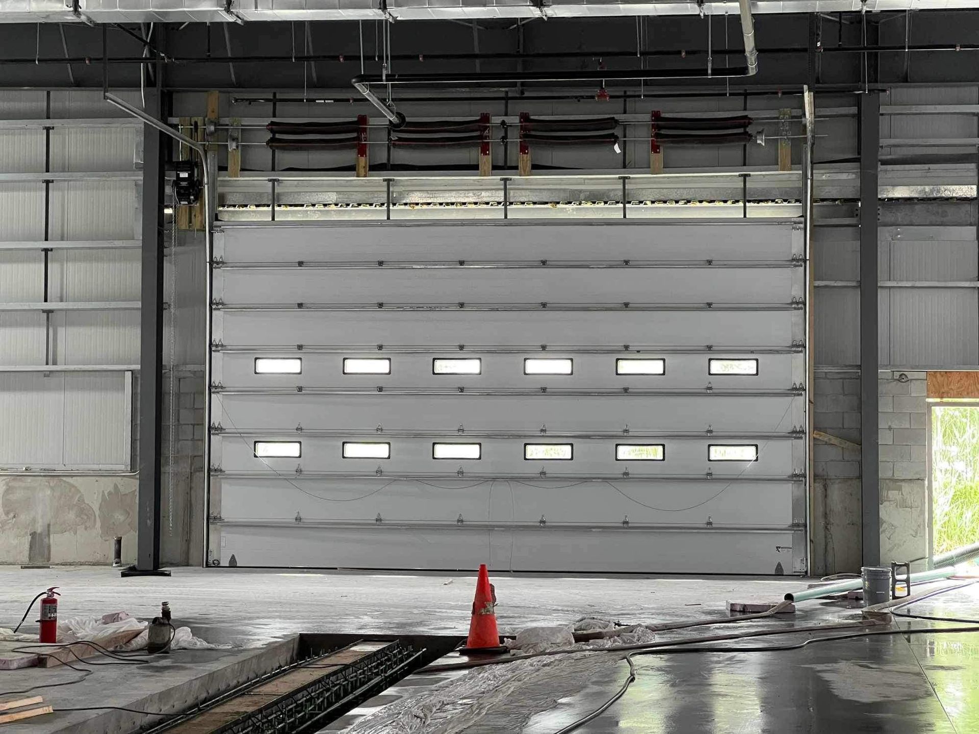 Large, closed, white industrial door in a warehouse, with small windows.