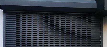 Dark gray rolling security gate, closed.