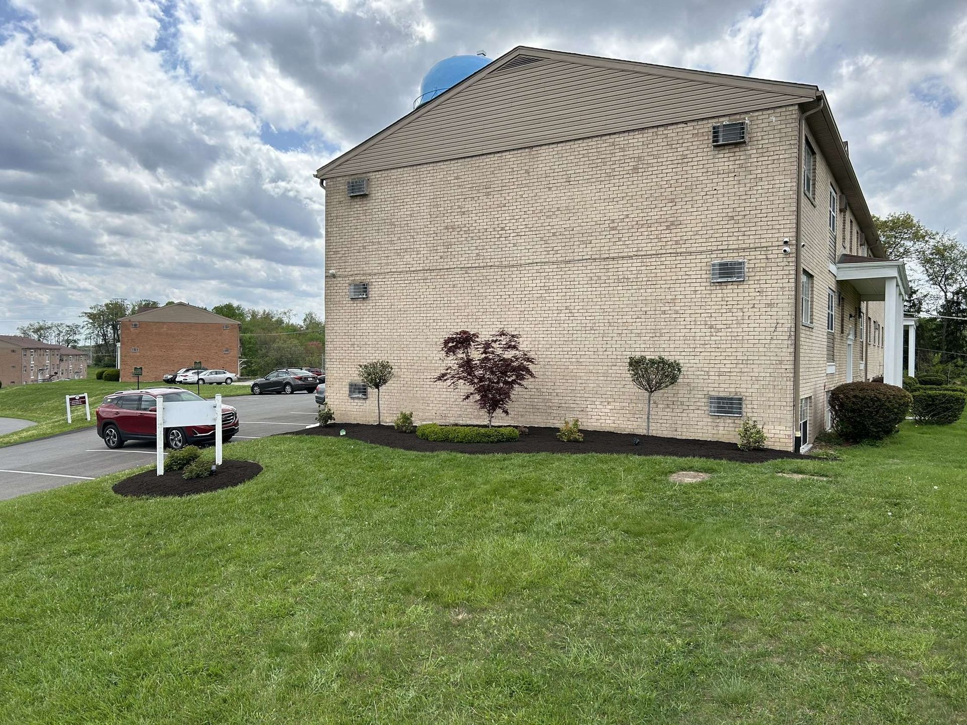 A large brick building with a lot of grass in front of it.