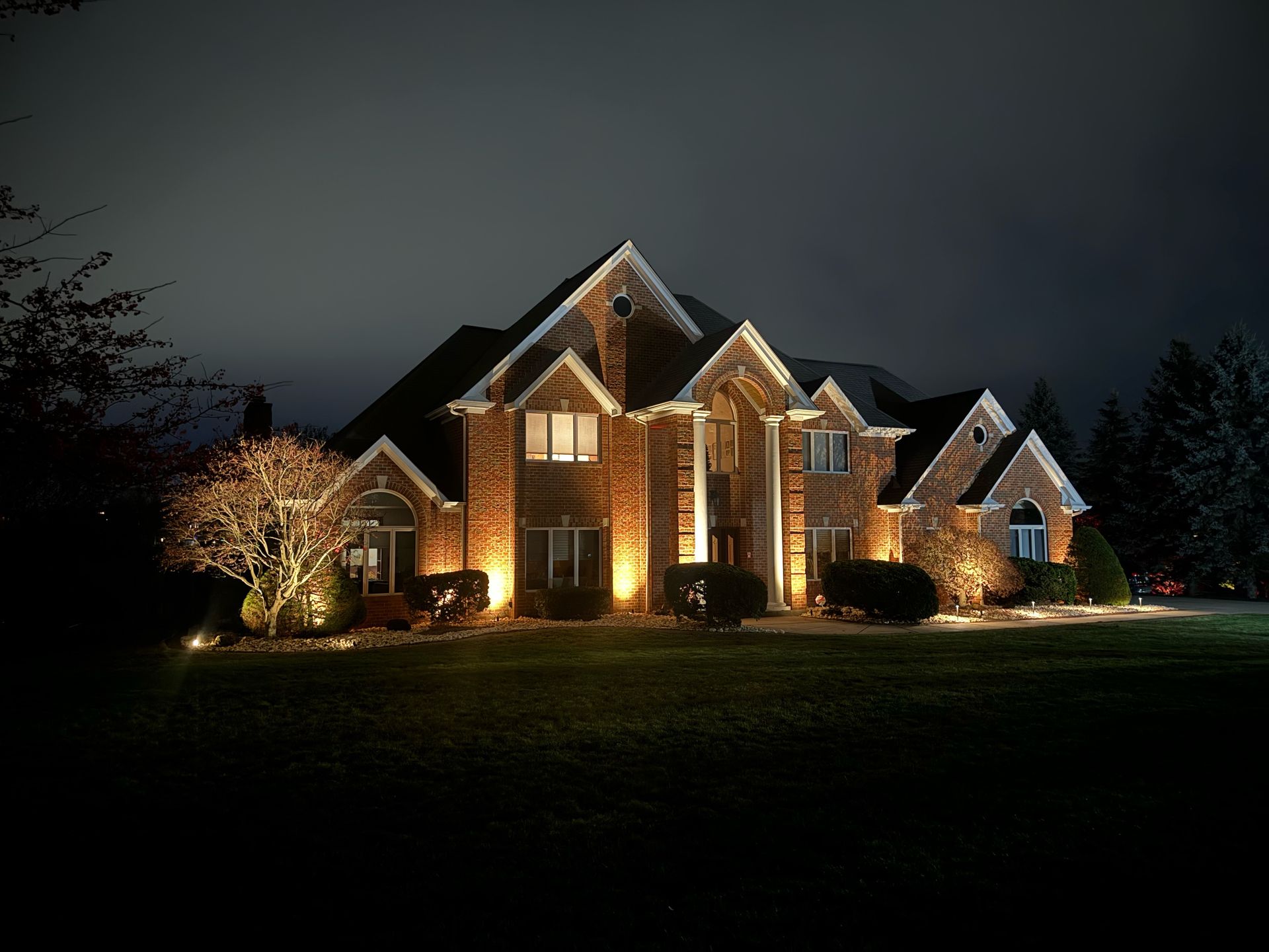 A large brick house is lit up at night