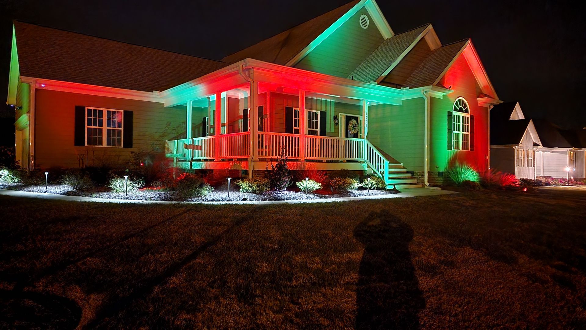 House illuminated with red and green lights for the holidays.