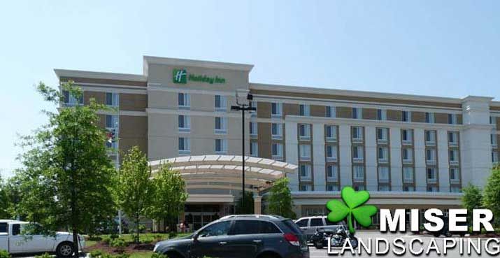 Holiday Inn hotel exterior with Miser Landscaping logo.