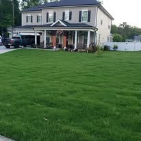 A two-story house with a green lawn.