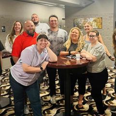 A group of people are posing for a picture in front of a table.