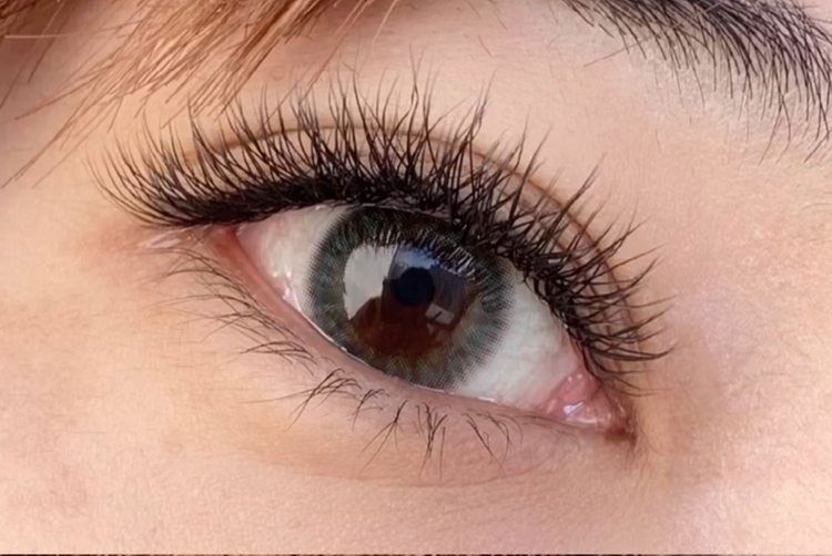 A close up of a woman 's eye with long eyelashes.