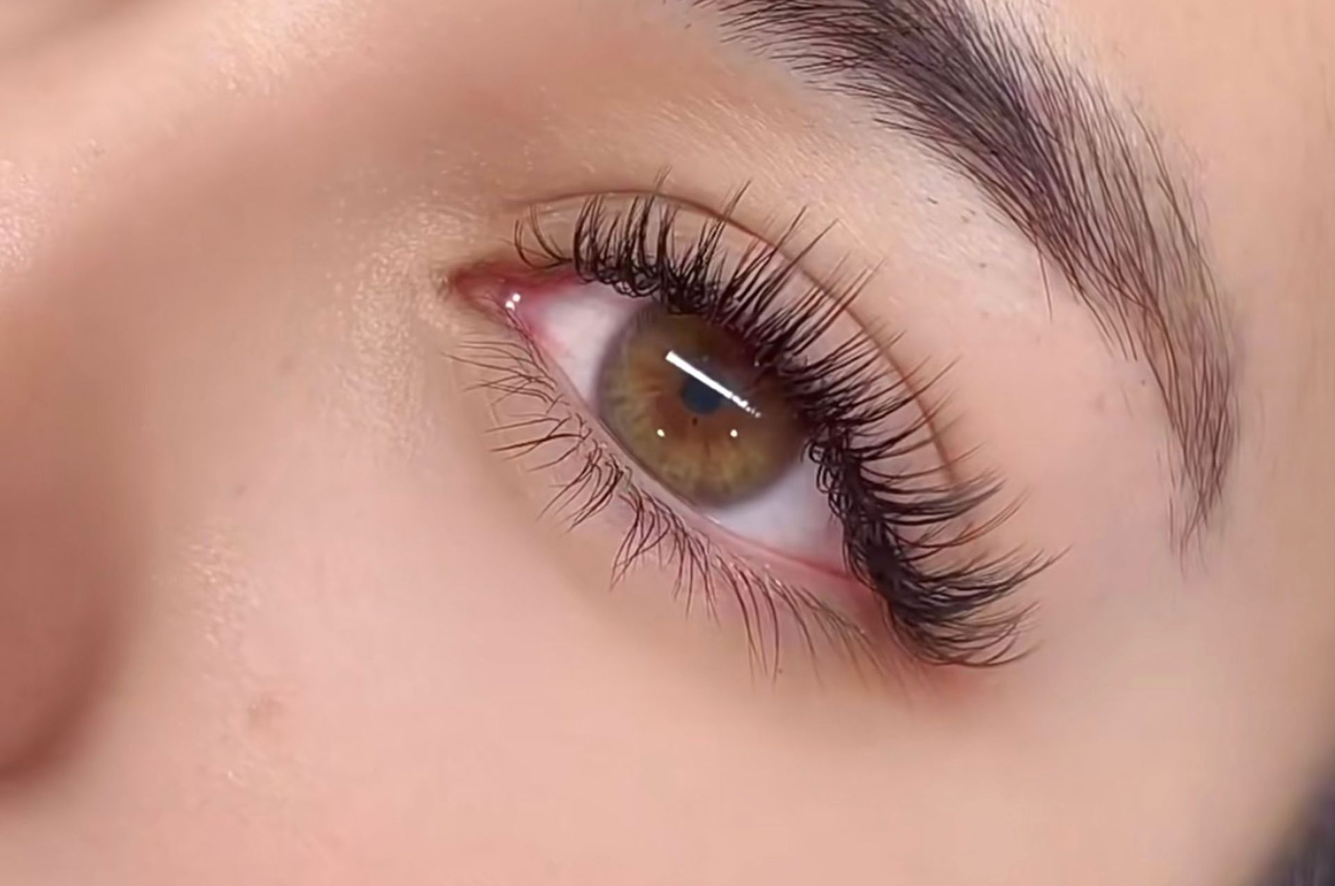 A close up of a woman 's eye with long eyelashes.