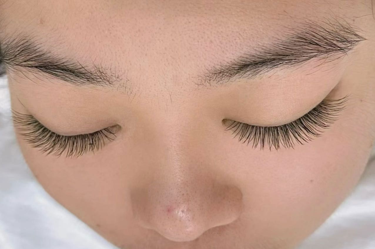 A close up of a woman 's face with her eyes closed.
