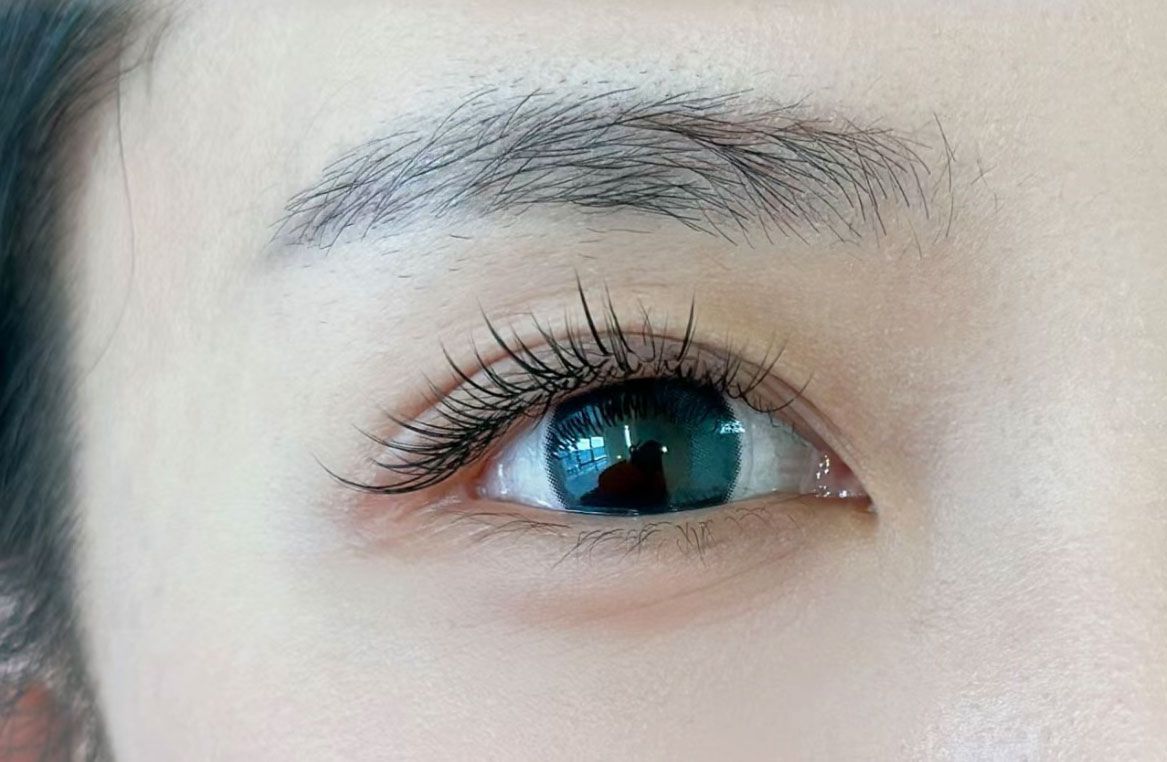 A close up of a woman 's eye with long eyelashes.