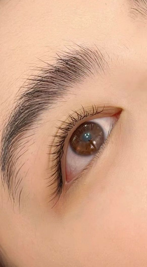 A close up of a woman 's eye with long eyelashes.