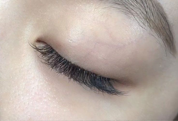 A close up of a woman 's eye with long eyelashes.