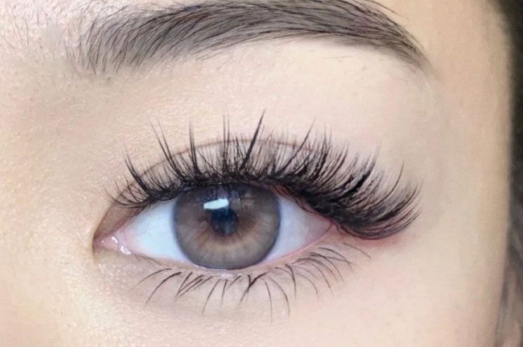 A close up of a woman 's eye with long eyelashes.