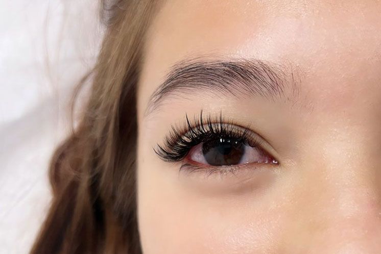 A close up of a woman 's eye with long eyelashes.