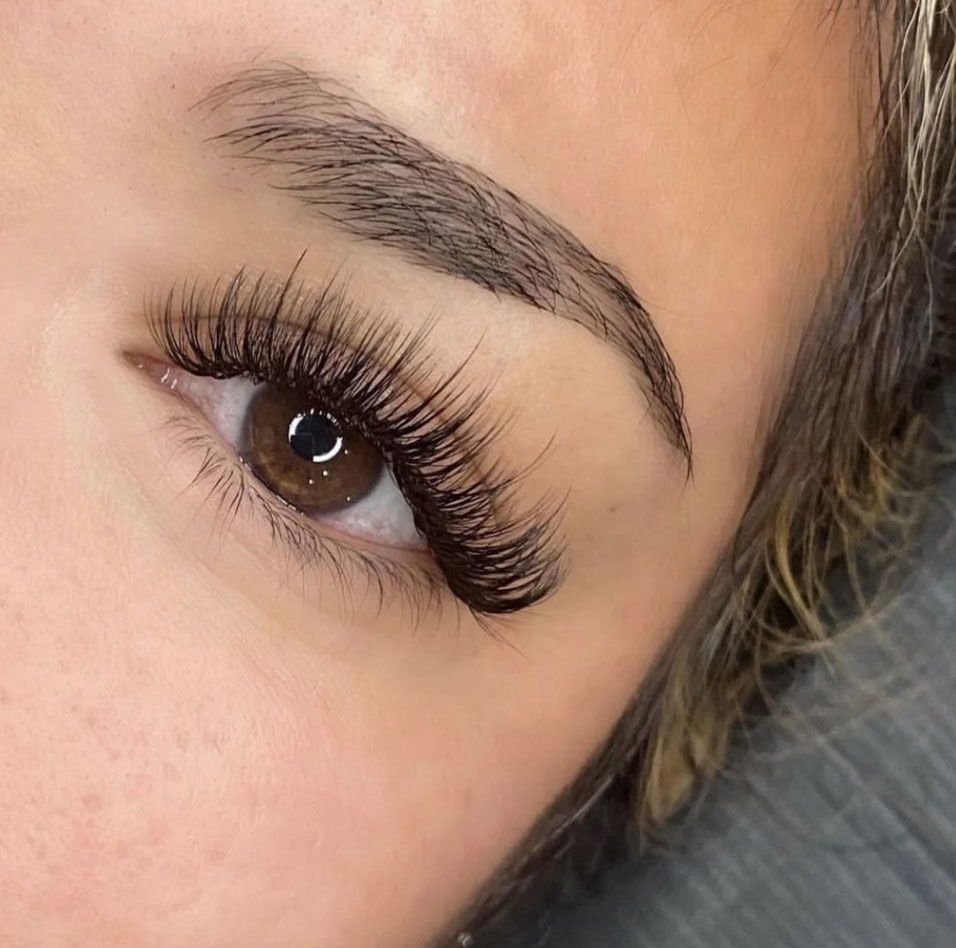 A close up of a woman 's eye with long eyelashes.
