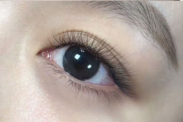 A close up of a woman 's eye with long eyelashes.