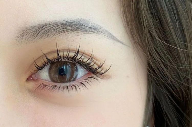 A close up of a woman 's eye with long eyelashes.