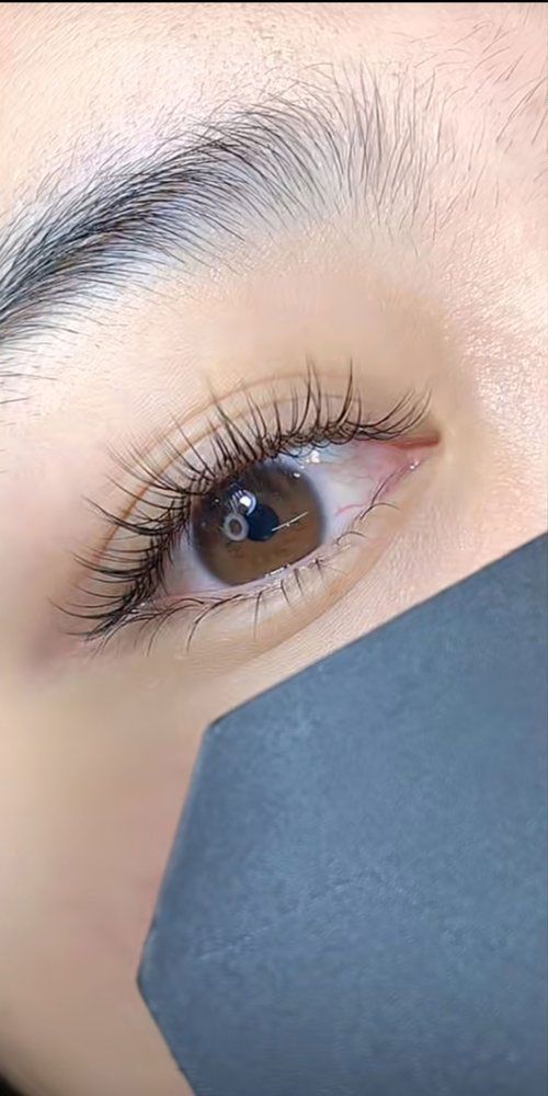 A close up of a woman 's eye with long eyelashes.