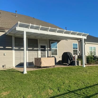 a white pergola in the backyard of a house
