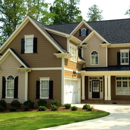 a large house with brown siding and black shutters