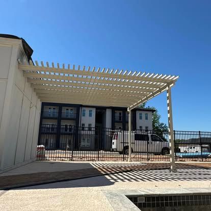 a white pergola near a fence