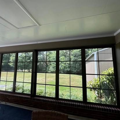 a living room with a lot of windows and a view of a field